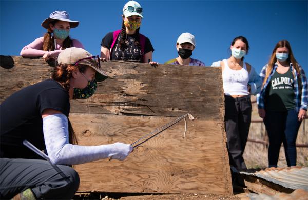 Emily Taylor showing students a snake on a class field trip