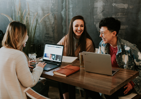 Three women talking and studying around a table