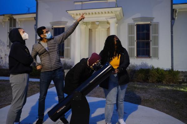 Image of docents helping visitors see the night sky.