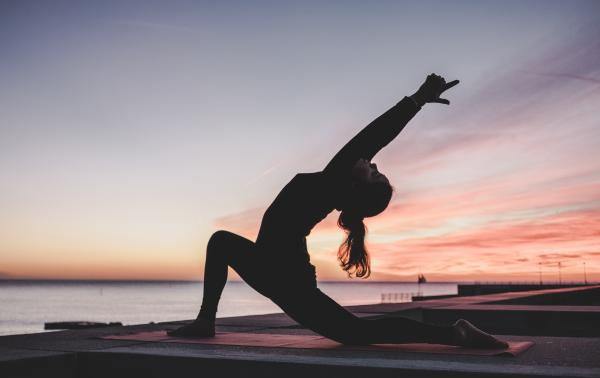 Silhouette of person doing yoga pose.
