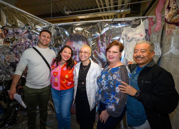A student and family members gathered in front of work at the 2022 Senior Exhibition