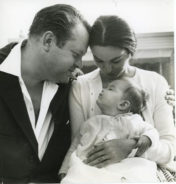 Orson Welles and Paola Mori look adoringly at their infant daughter, Beatrice (c. 1955).