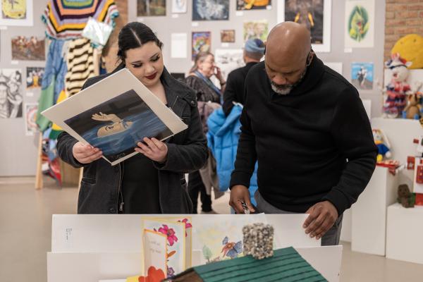 Two gallery attendees looking at artwork from the Annual Exhibition