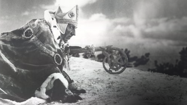 Black and white screen cap taken from the film Alexander Nevsky, actor depicting Prince Alexander in royal armor seen kneeling on the left. Canons can be seen behind him in the background.