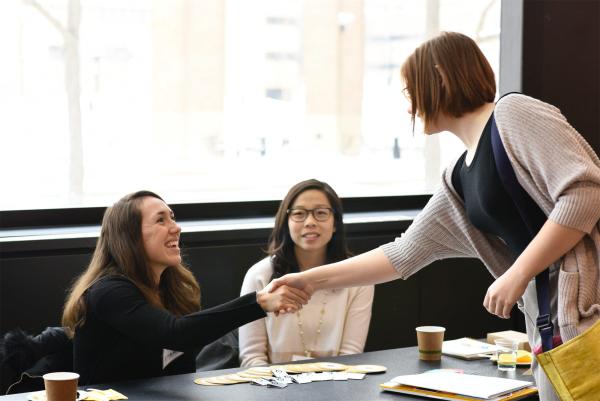 two women shaking hands in greeting