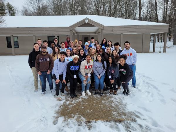 Fraternity and Sorority members posing at a Leadership Retreat outside in the snow