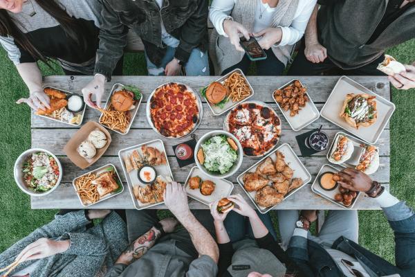 Long picnic table of people with german food