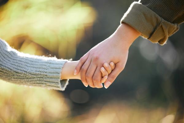A child and an adult holding hands