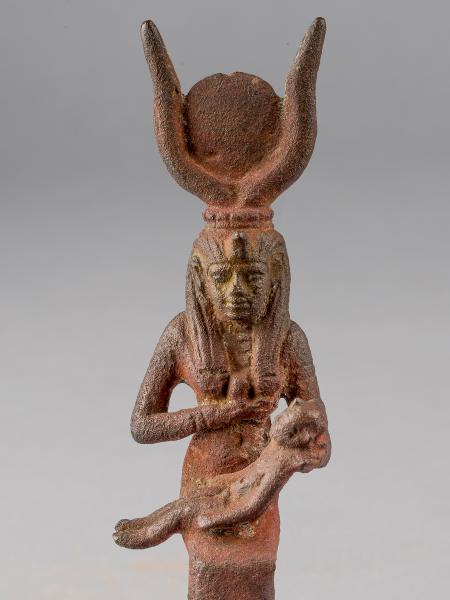 Bronze figurine of the Egyptian goddess Isis breastfeeding her son, Horus. She has the horns of a cow on her head with a solar disk between them.