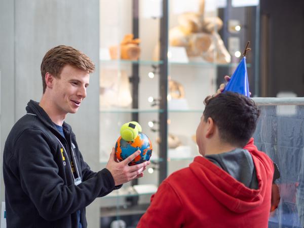 Researcher Nathan Bryant shows a young visitor a giant molecule model