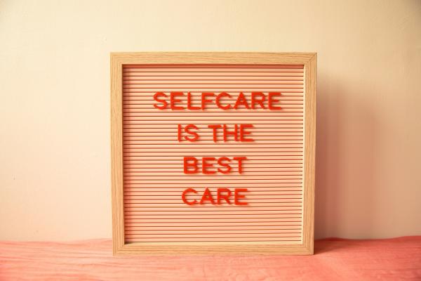 A peach colored sign that says "Self Care is the best care"