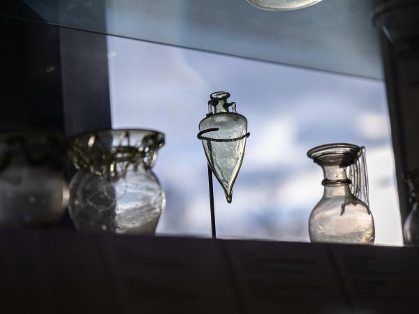 View of a Kelsey Museum display of ancient glass. At the center is a vessel resembling a mini amphora.