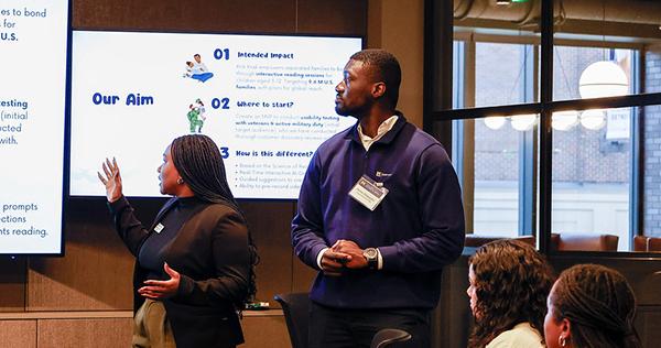 Two people presenting to a small crowd
