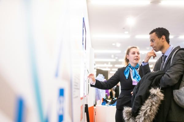 Two people look at a poster