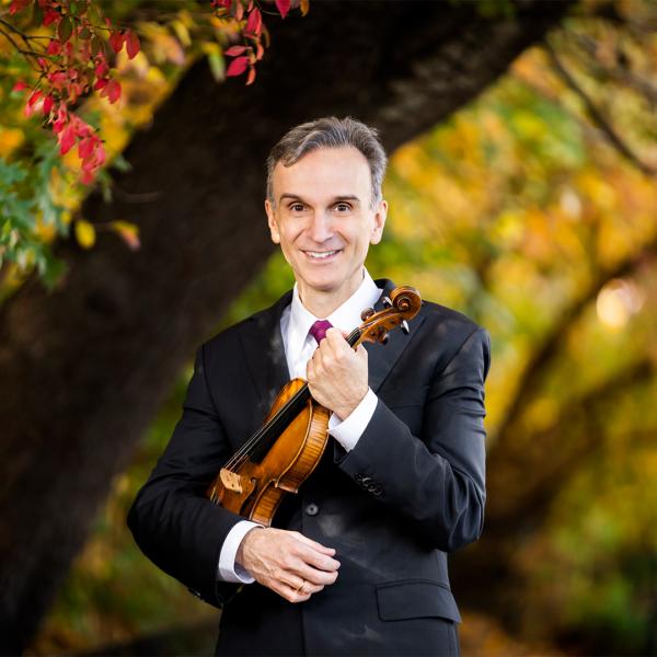 Gil Shaham holding violin with trees in background