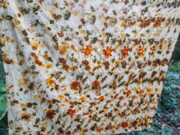 A large piece of cotton with flowers printed on it hangs on a cord.
