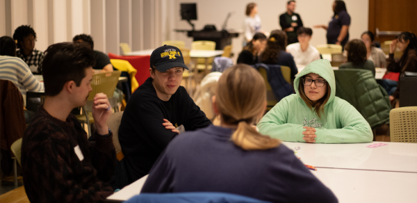 Four students have a conversation around a table