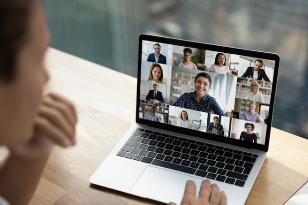 Laptop screen showing different faces in a virtual meeting.