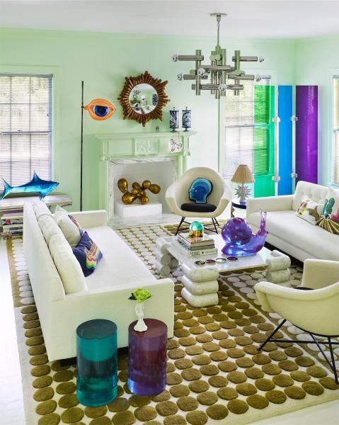 A living room, with colorful decor and several sofas arranged on a rug