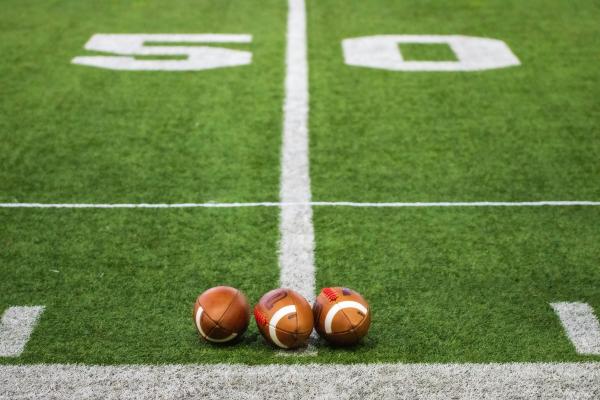 Three footballs on a field