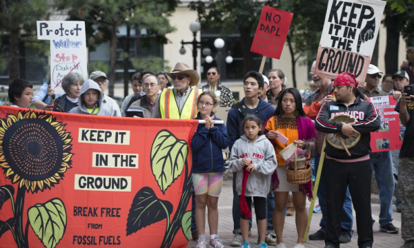 Group protesting fossil fuels with sign reading Keep it in the Ground