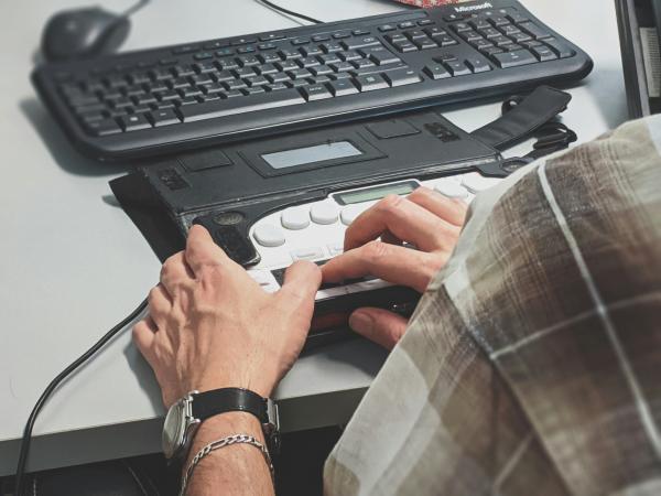 A person uses an accessibility tool to access technology.