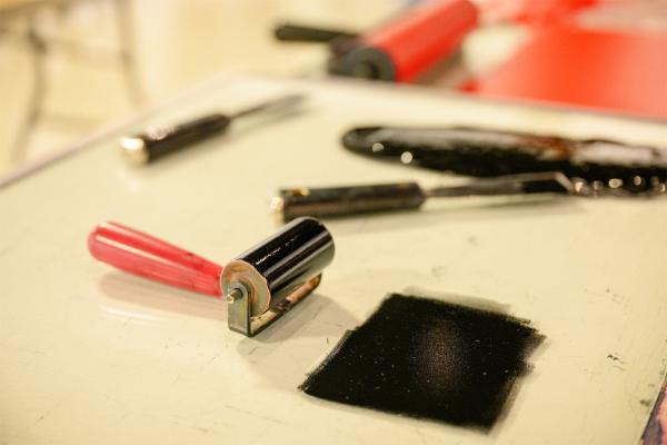 A printmaking roller covered with black ink