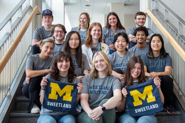 group of Minor in Writing students sitting on stairway smiling