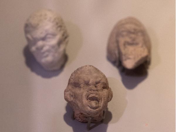 Close-up of three Seleucid grotesques on display at the Kelsey Museum.