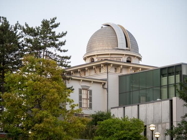 The Detroit Observatory dome above greenery.