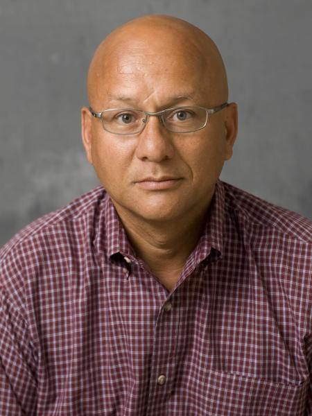 A man in glasses looks into the camera