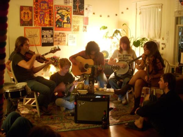 Film photo of a group of friends writing a song together in a living room.