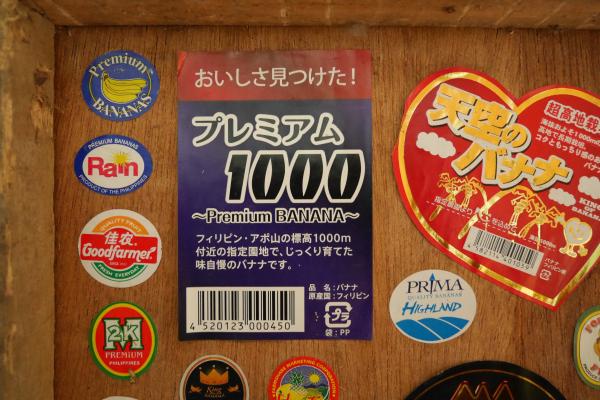 A photo of a variety of colorful fruit stickers from bananas in a mix of Japanese and English.
