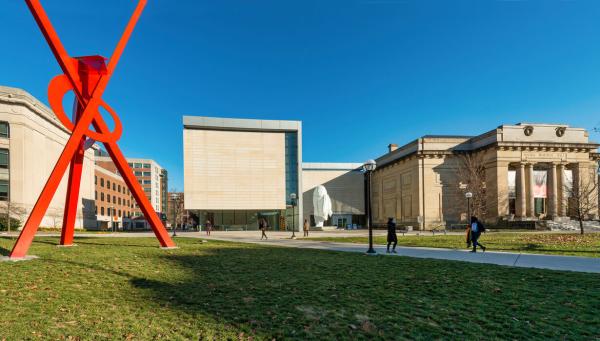 Exterior of University of Michigan Museum of Art building made of beige stone with a large red sculpture on the front lawn