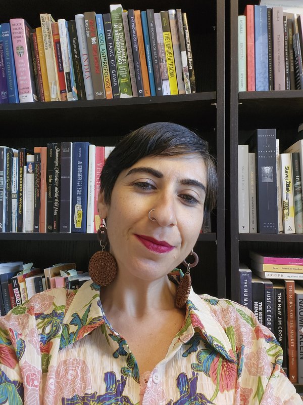 Tamar Shirinian smiling in front of a bookshelf