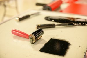 A printmaking roller covered with black ink