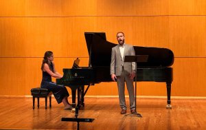 A vocalist and collaborative pianist perform on stage.