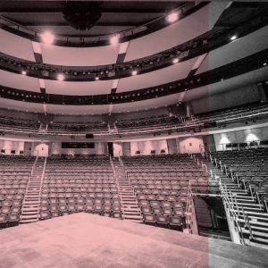 The empty Power Center auditorium with curving rows of seats and dramatic overhead lighting.