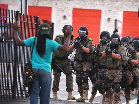 Police pointing automatic weapons at an unarmed protestor in Ferguson, Missouri