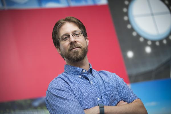 Bearded man with glasses standing in front of building