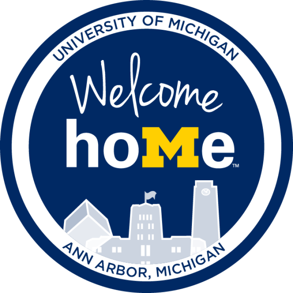 Blue circle with "Welcome Home" written in the middle above the skyline of the Michigan Union