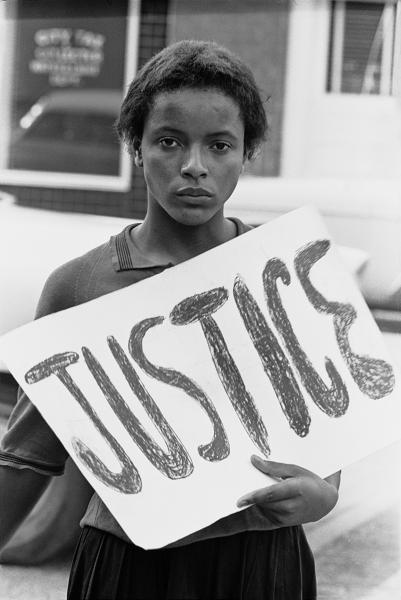Women at march holding a "Justice" sign