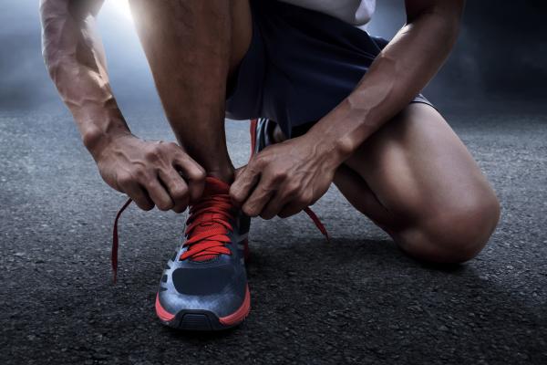 Runner lacing up shoes