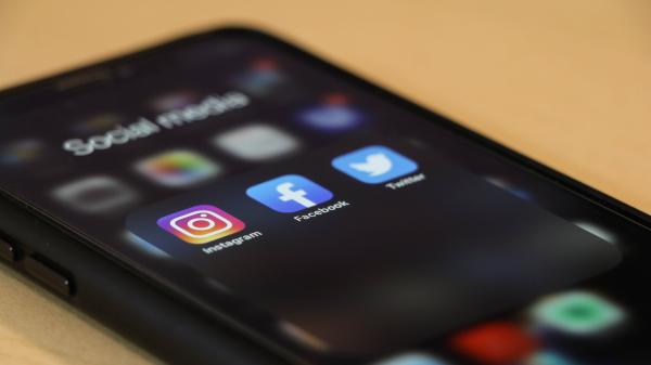 A phone showing the Instagram, Facebook, and Twitter apps