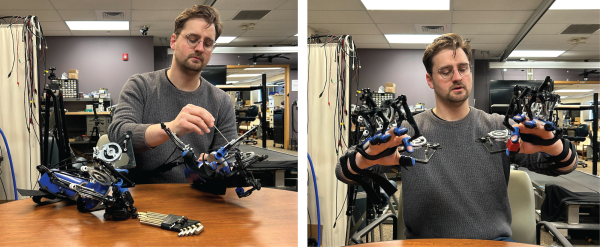 A researcher adjusts and wears a hand exoskeleton with attachments on the forearm and each fingertip.